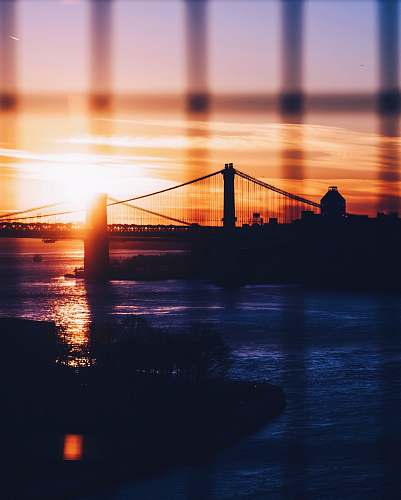 sunrise silhouette of Brooklyn and Manhattan Bridges during golden hour sunset